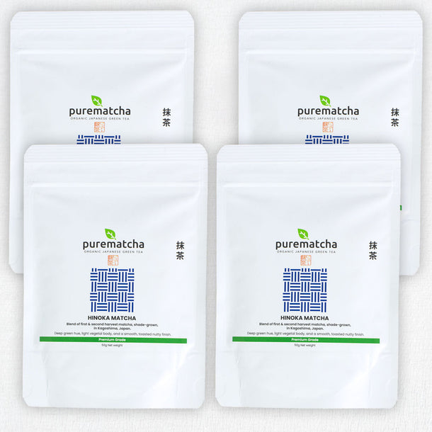 Four white pouches of purematcha tea on a white background