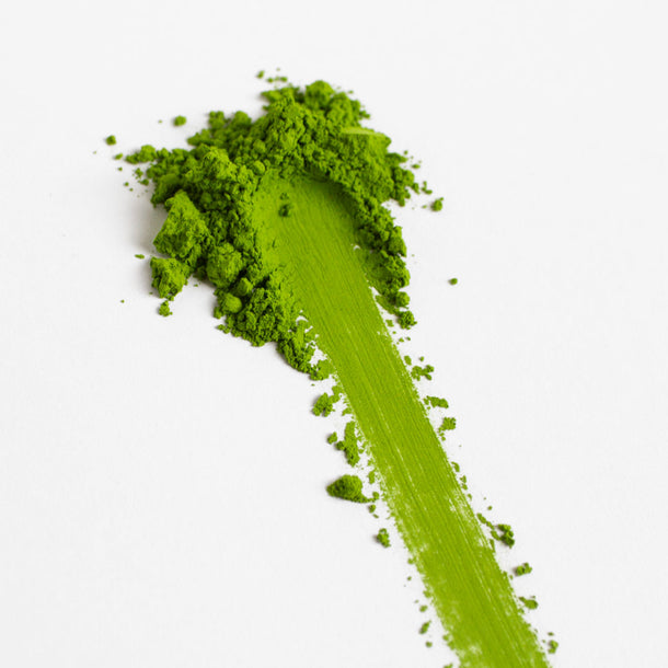 Organic ceremonial Green powder with a streak on a white background