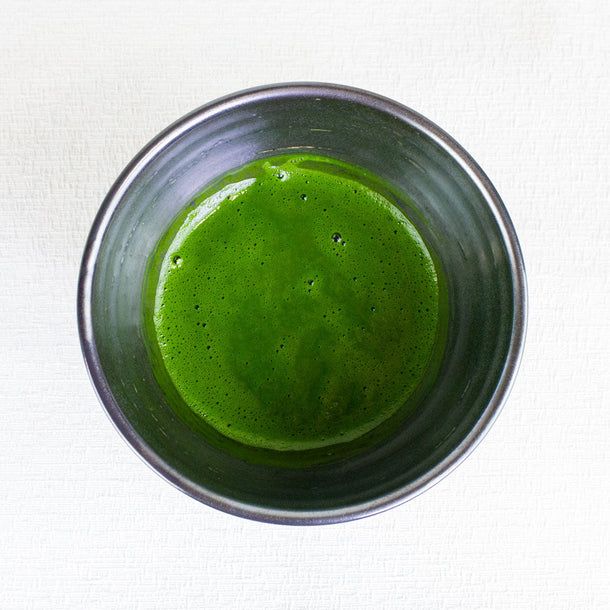 matcha green tea whisked in a black matcha tea bowl