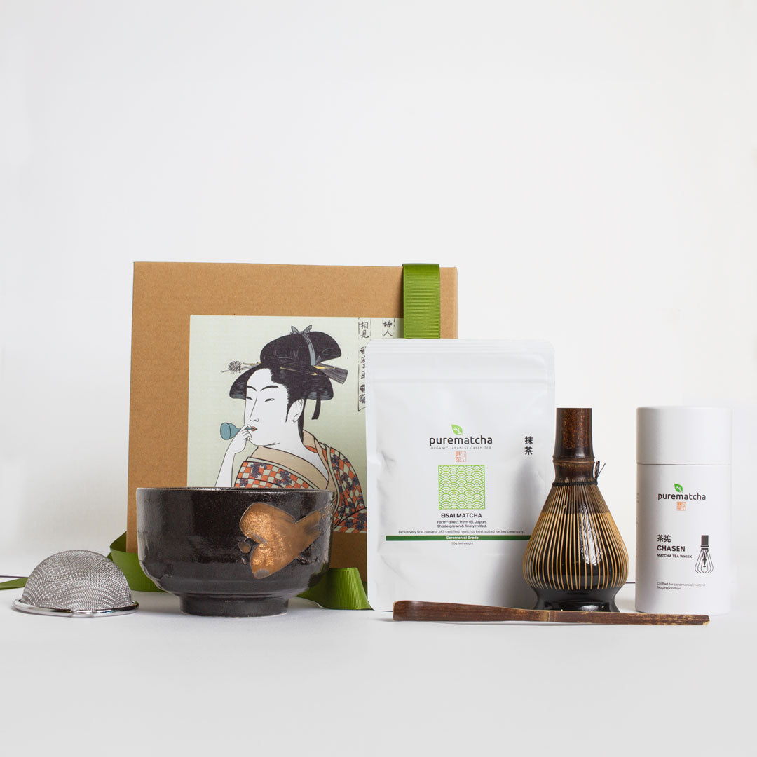 Tea-making set with a bowl, whisk, and packaging on a white background