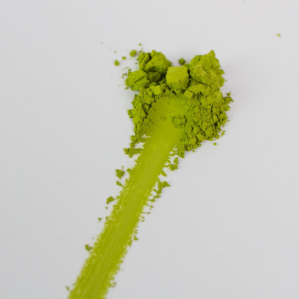 Green powder with a streak on a white background