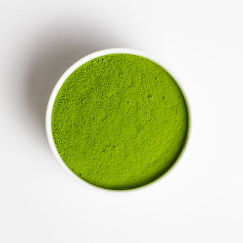 Ceremonial Matcha Green powder in a white bowl on a white background