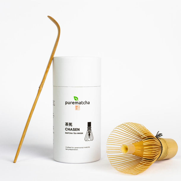 White container labeled 'purematcha' with a bamboo whisk and scoop on a white background
