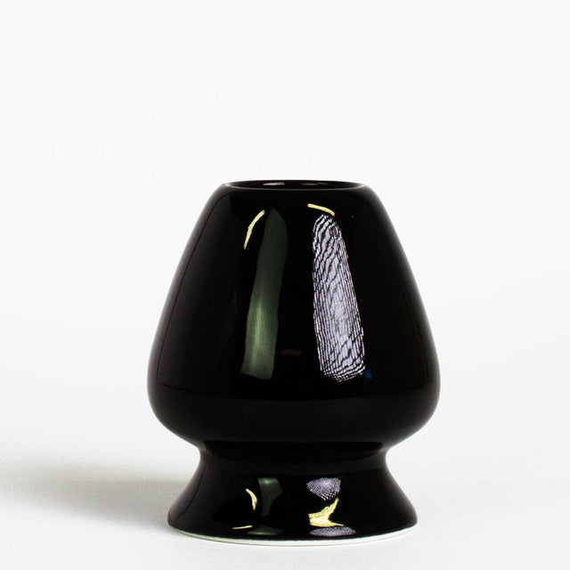 black ceramic matcha tea whisk stand on white background
