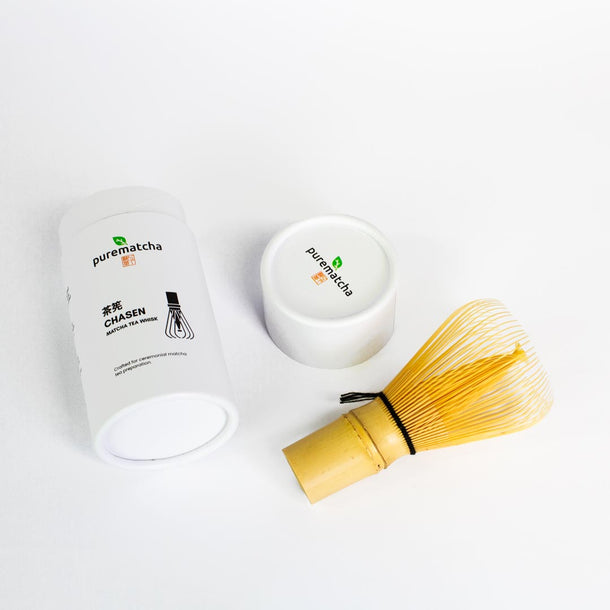 Matcha preparation set with white container, bamboo whisk, and pouch on a white background